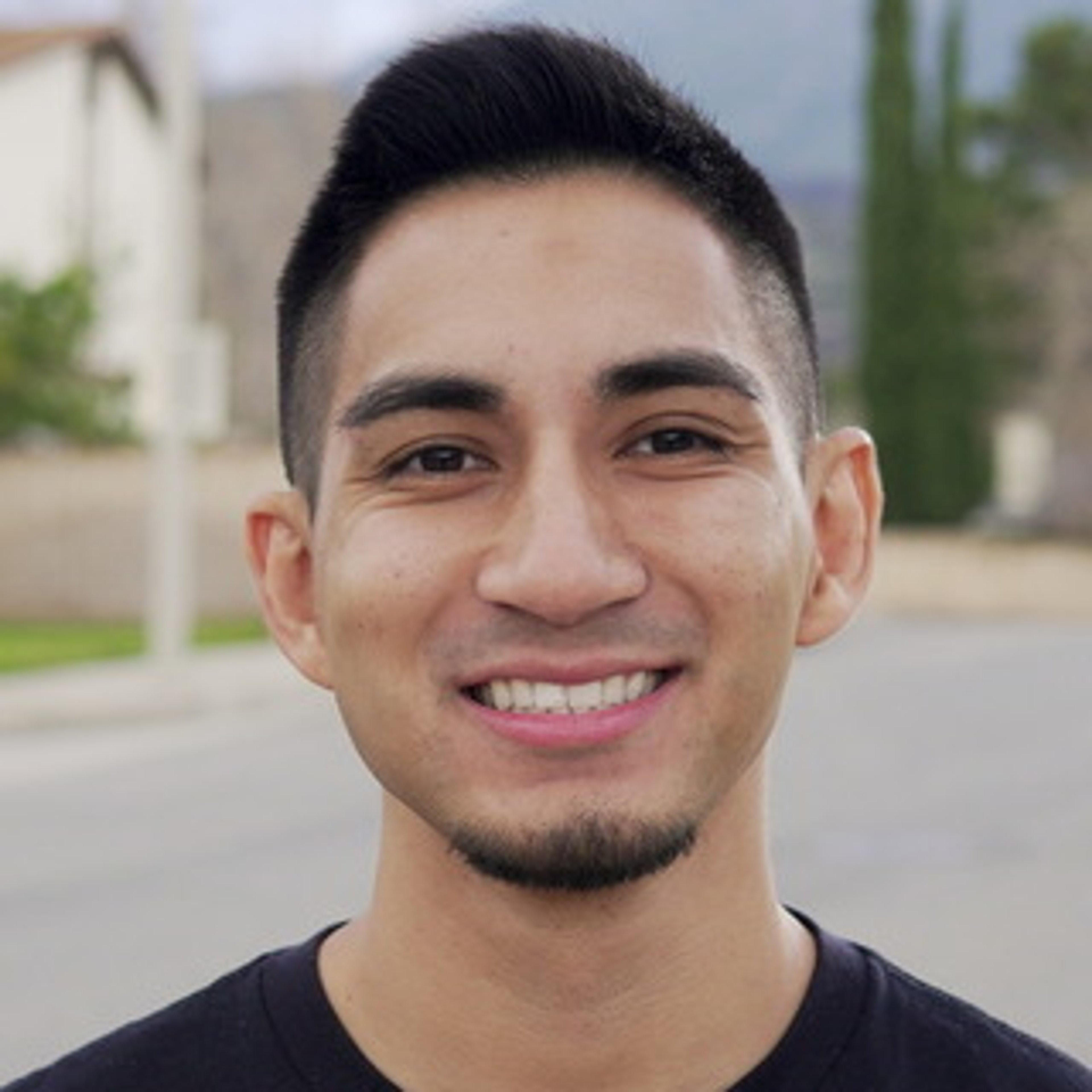 A smiling young man with short dark hair