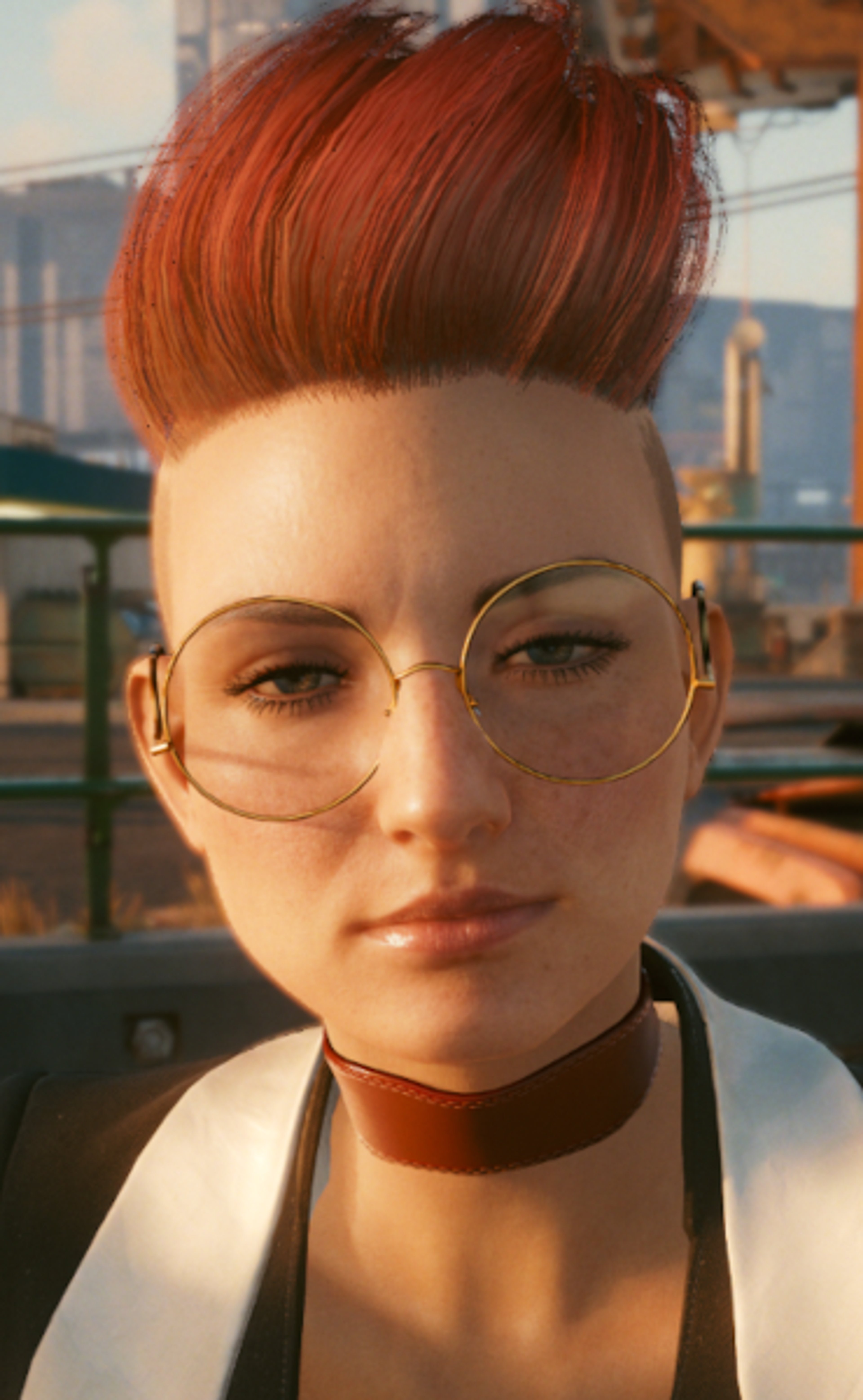 A woman with red mohawk-style hair and glasses wearing a white shirt