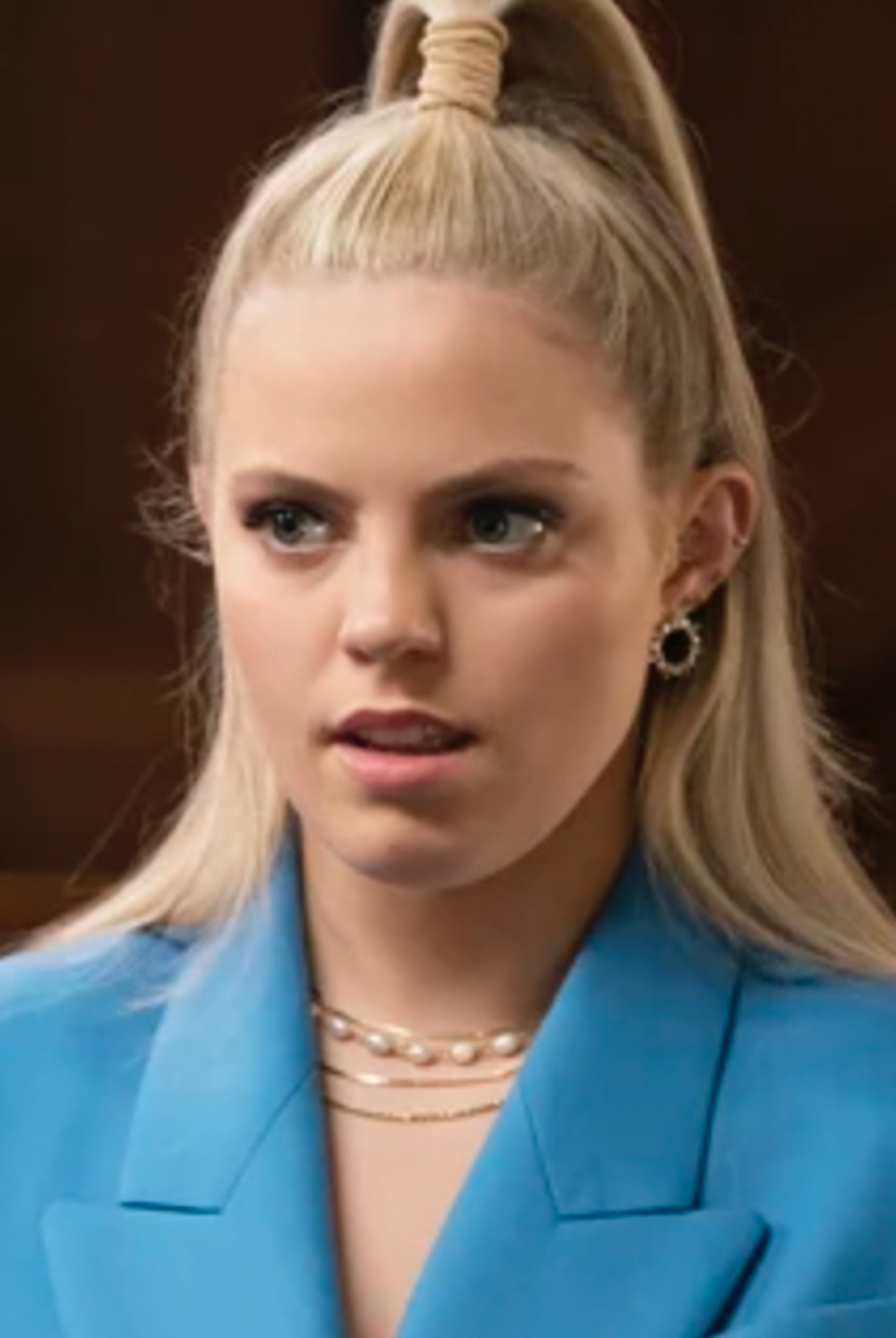 A young woman with blonde hair in a ponytail wearing a blue blazer