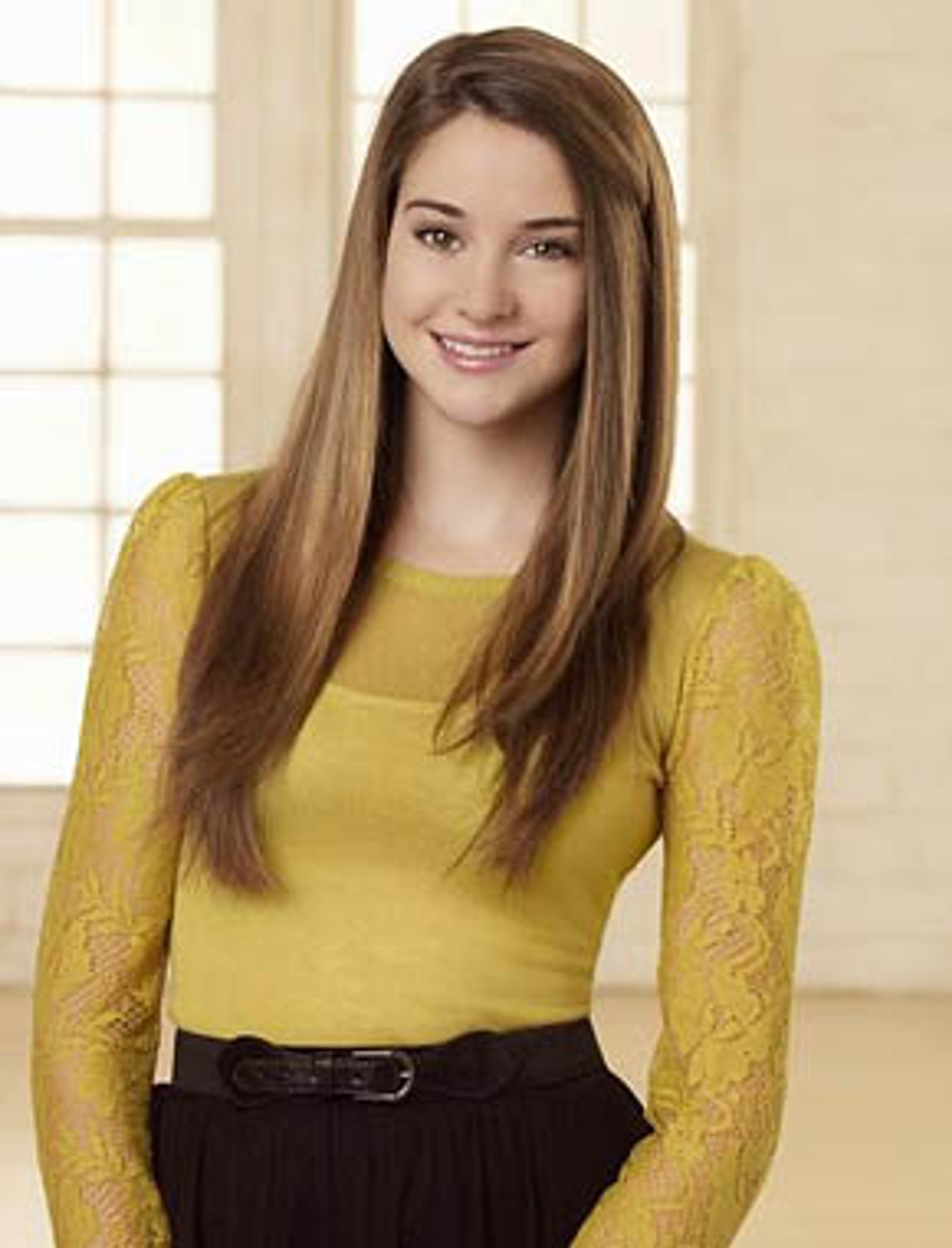 A young woman with long brown hair smiling at the camera