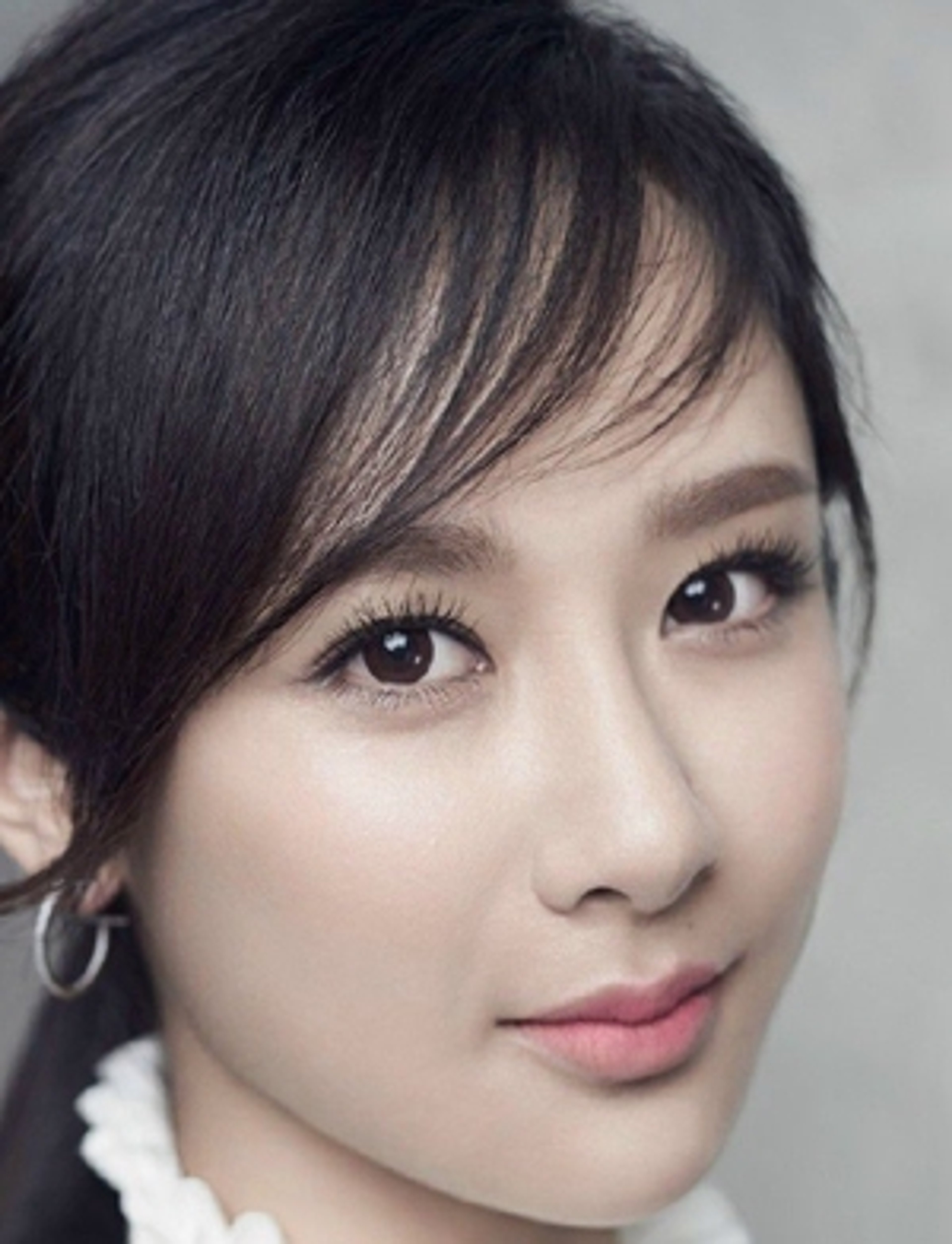 A young, beautiful Asian woman with long dark hair and a serene expression