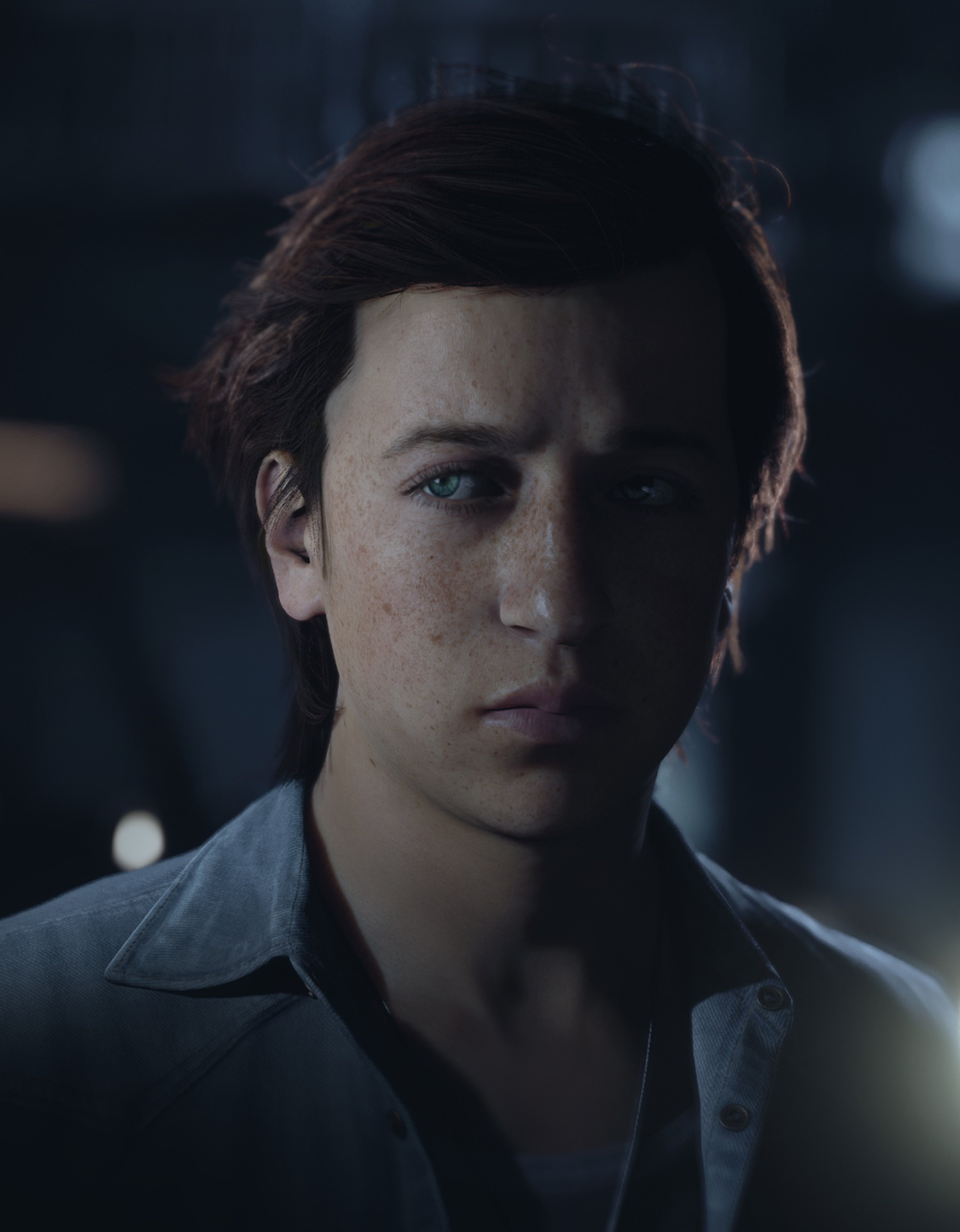 A young man with messy, reddish-brown hair and freckles, wearing a casual button-up shirt.