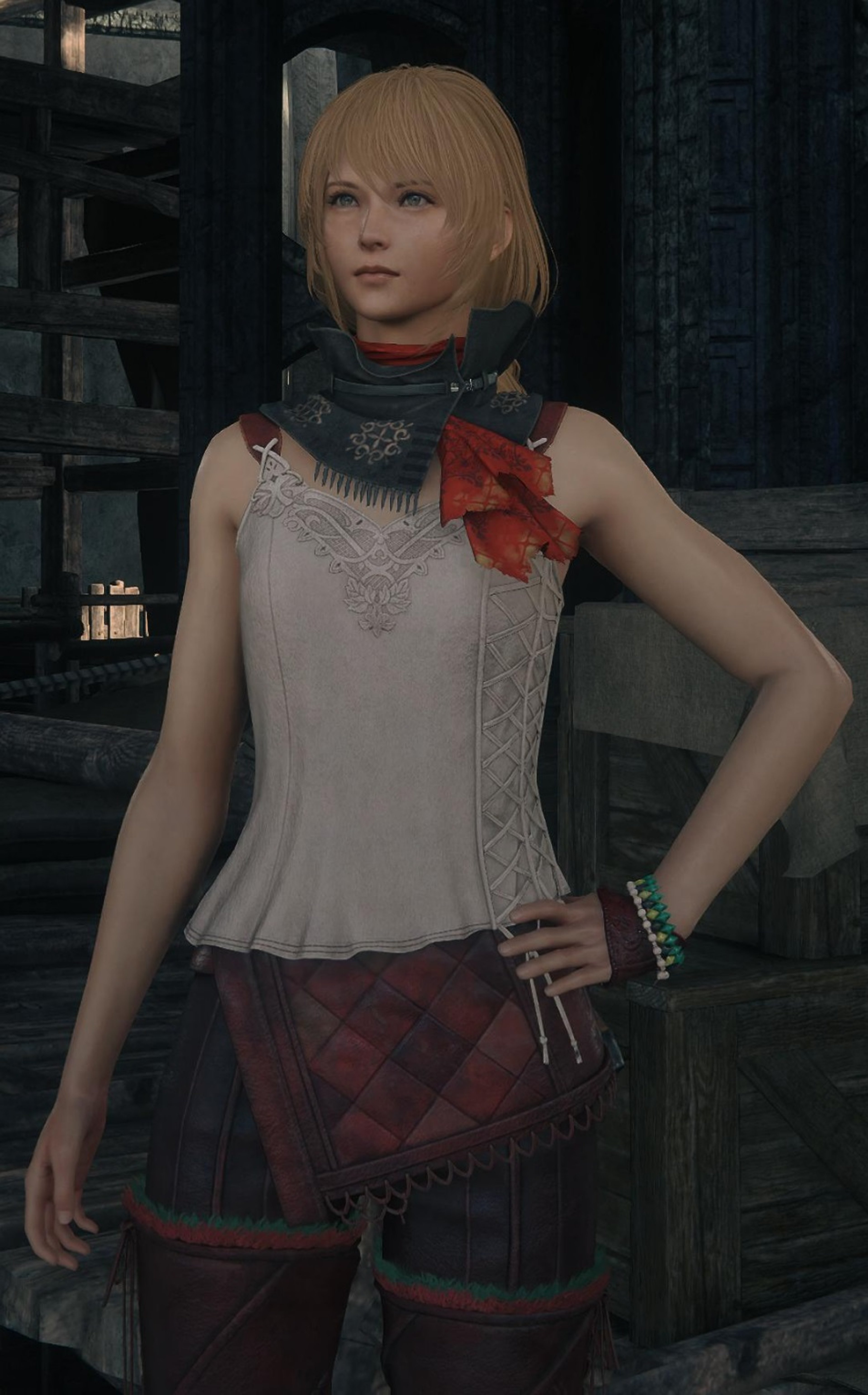 A young woman with blonde hair and a confident expression, wearing a gray top and plaid skirt.