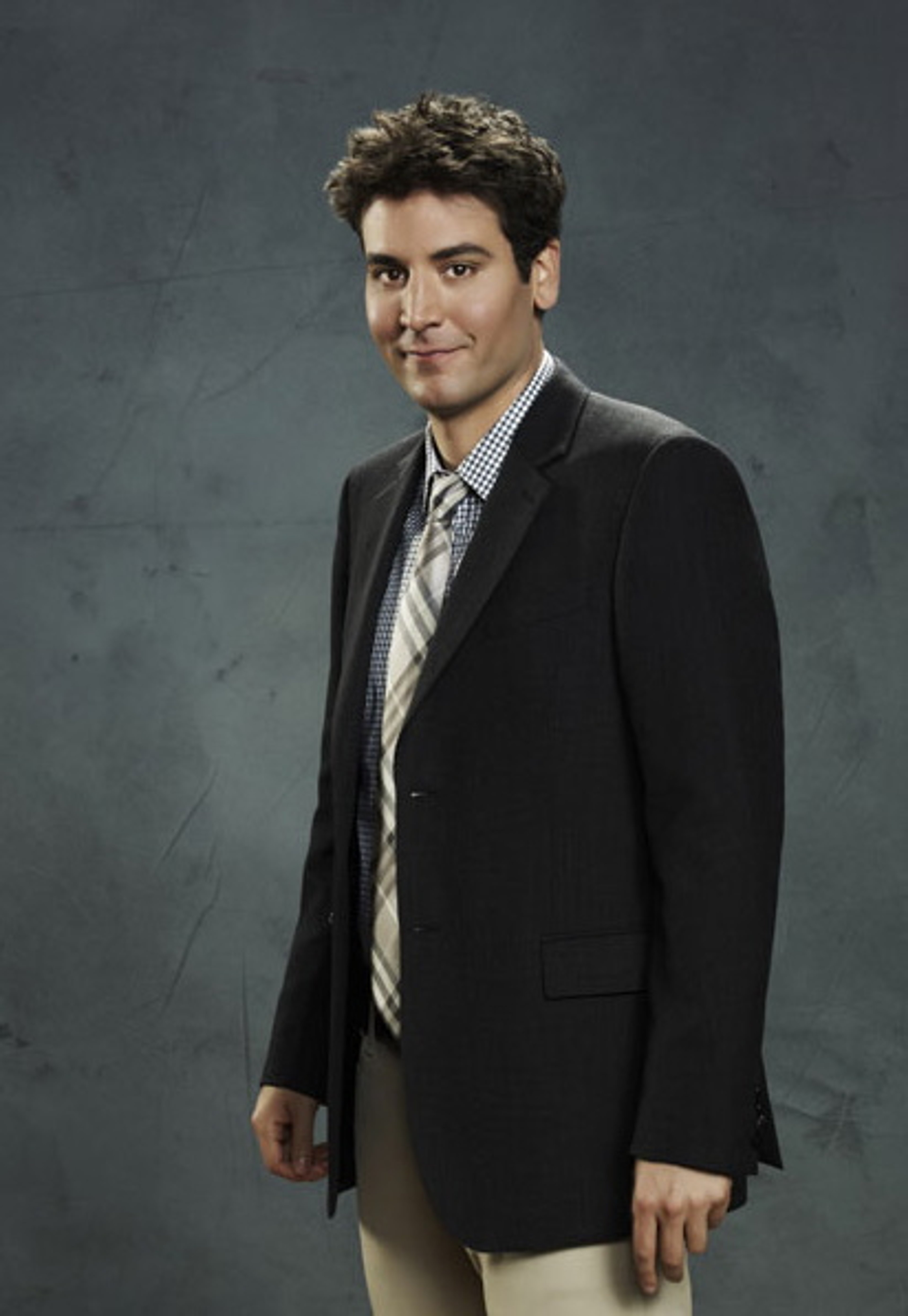 A man in a suit and tie with curly brown hair