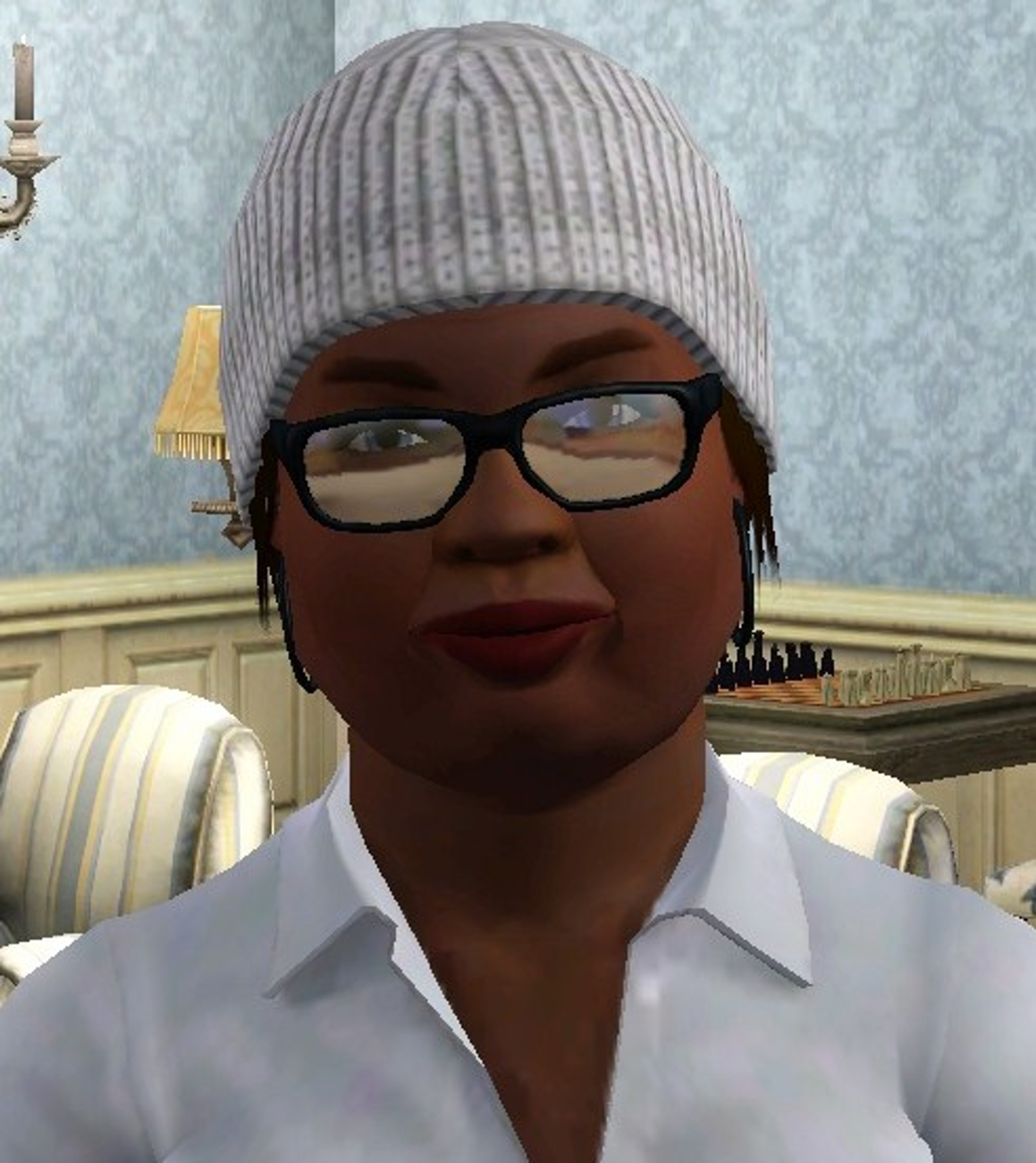 A person wearing a gray hat and glasses sitting in a room