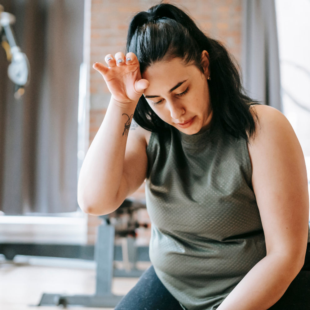 Frau sitzt im Gym Frau sitzt im Gym