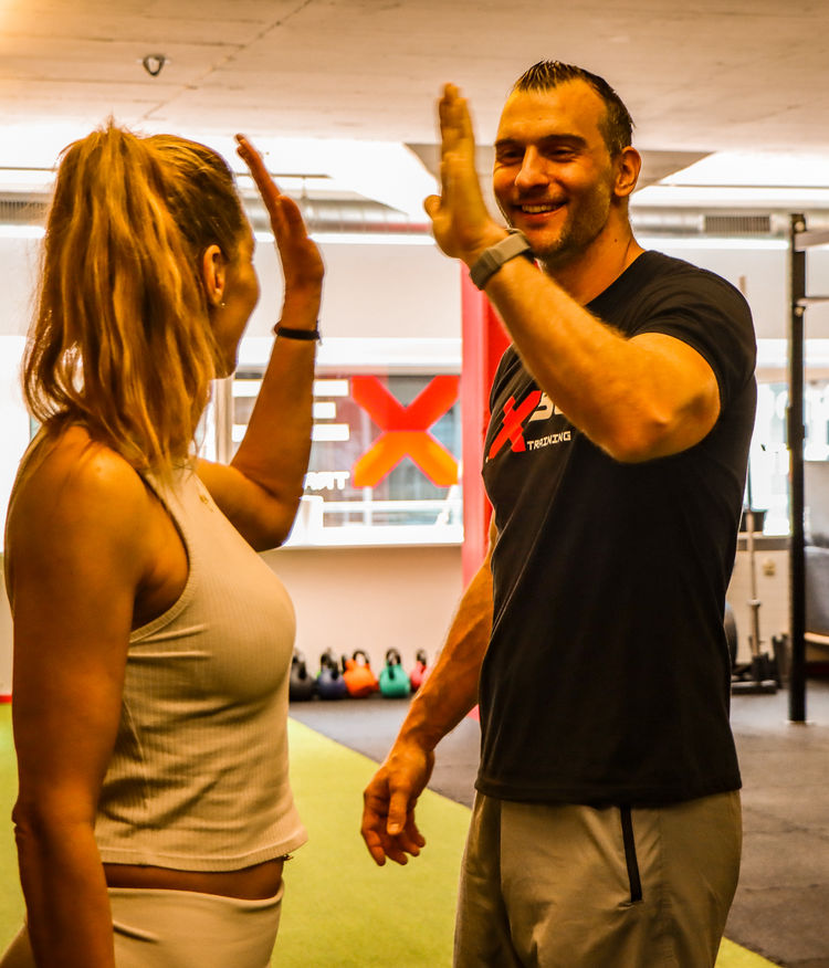 Pascal Blunschi klatscht sich mit einer Kundin nach dem Training ab