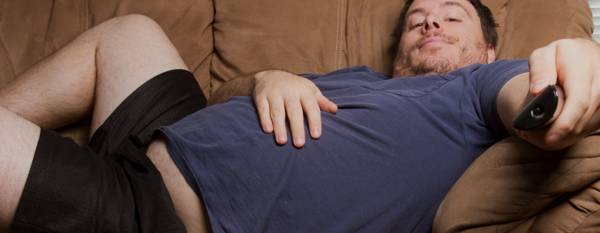 Man liegt unmotiviert auf Couch Man liegt unmotiviert auf Couch