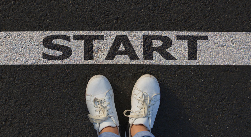 Person steht vor Startlinie Person steht vor Startlinie