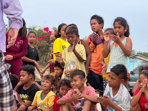 indigenous children gathered at a basketball court