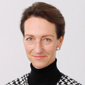 Headshot of Christine Stimpel, a midle-aged woman on a light gray background. 