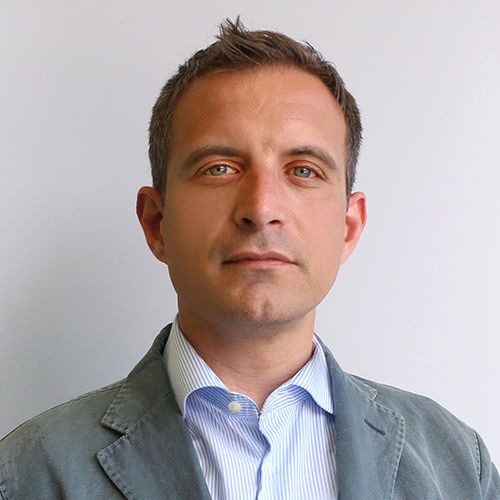 Headshot of Federico Frattini, a man in a suit on a simple light gray background.