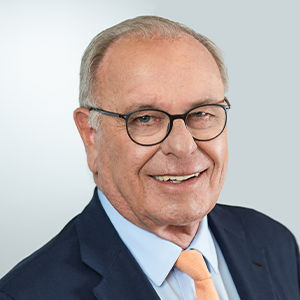 Headshot of Randolf Rodenstock, a midle-aged man in a suit on a simple light gray background. 