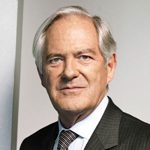 Headshot of Roland Berger, a midle-aged man in a suit on a simple light gray background. 