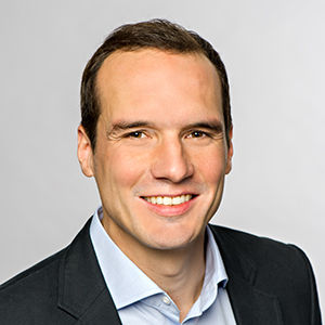 Headshot of Prof. Dr. Sebastian Schwenen , a middle age man smiling on a simple white  background.