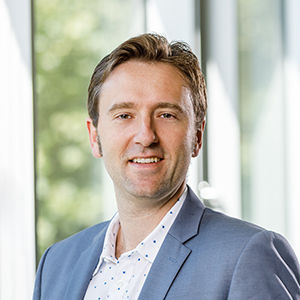 Headshot of Prof. Dr. Sebastian Müller,, a middle age man smiling on a simple background.