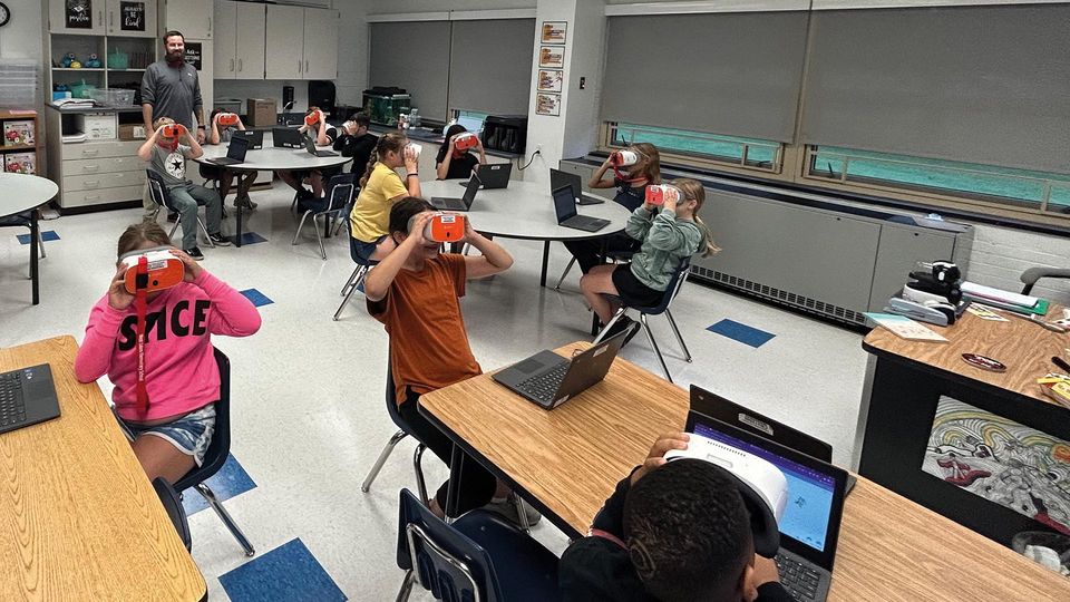 Classroom of students wearing VR headsets, engaging in STEM learning within an Augmented Reality Lab.