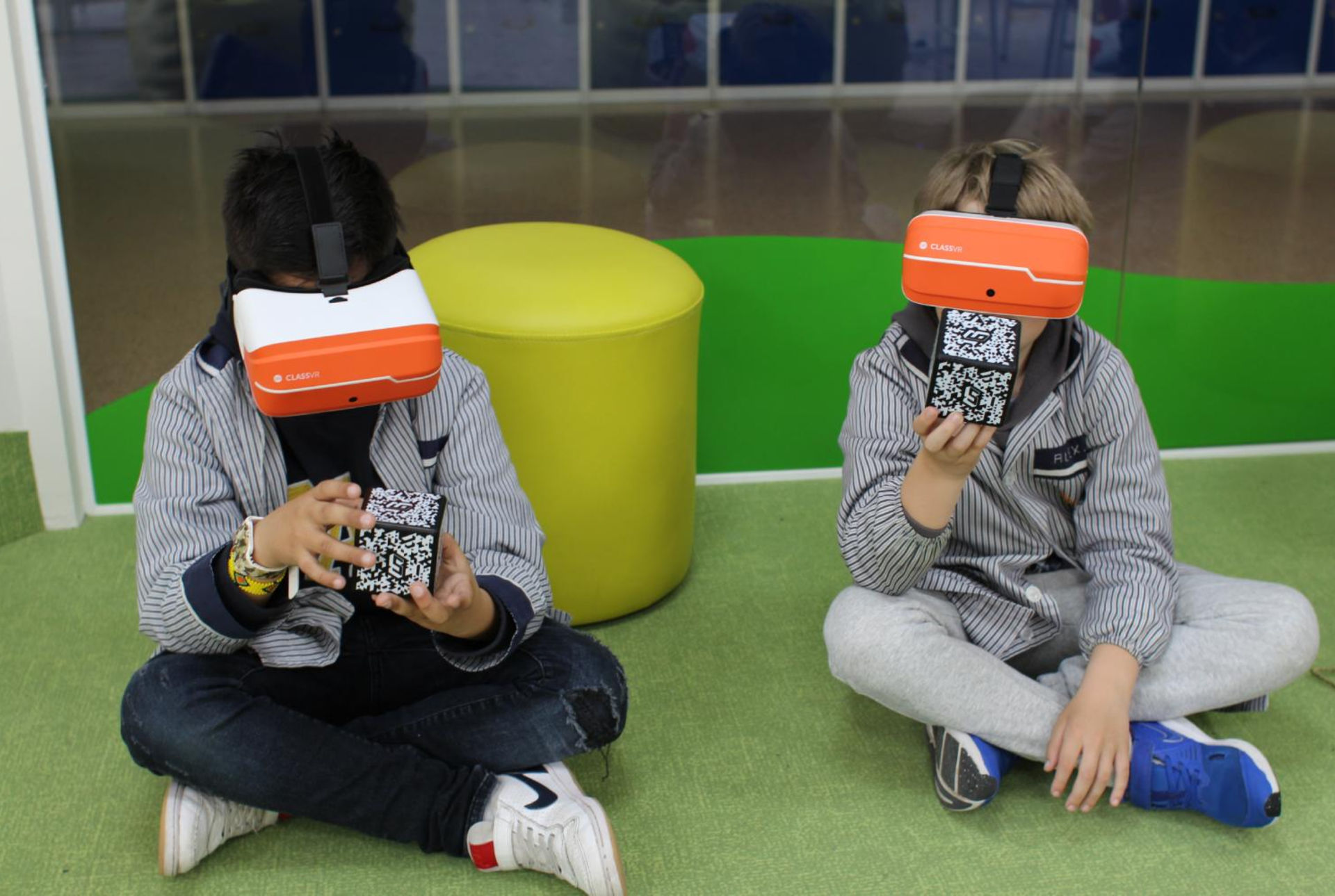 Two students sat down wearing VR headsets and using AR cubes