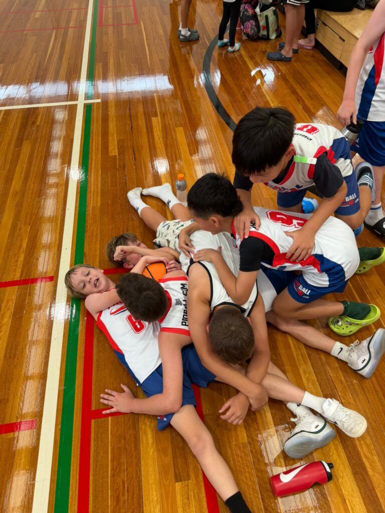 Young ProBall basketball players competing in a game, focused under pressure but laughing and representing youth athlete development.