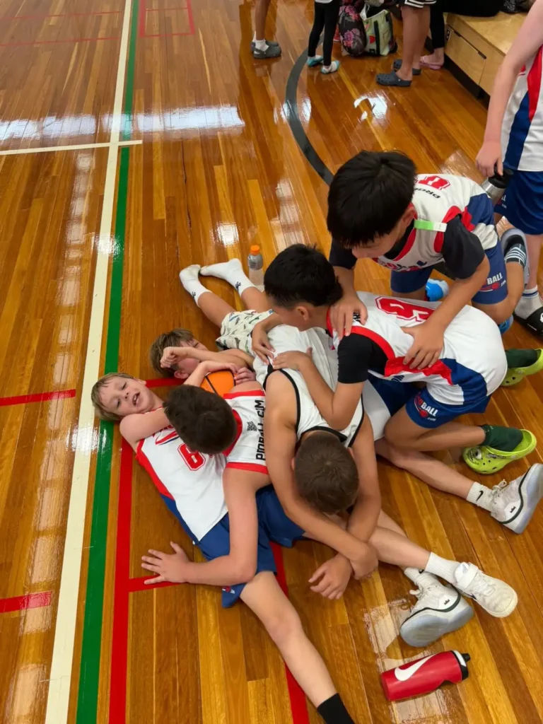 Young ProBall basketball players competing in a game, focused under pressure but laughing and representing youth athlete development.