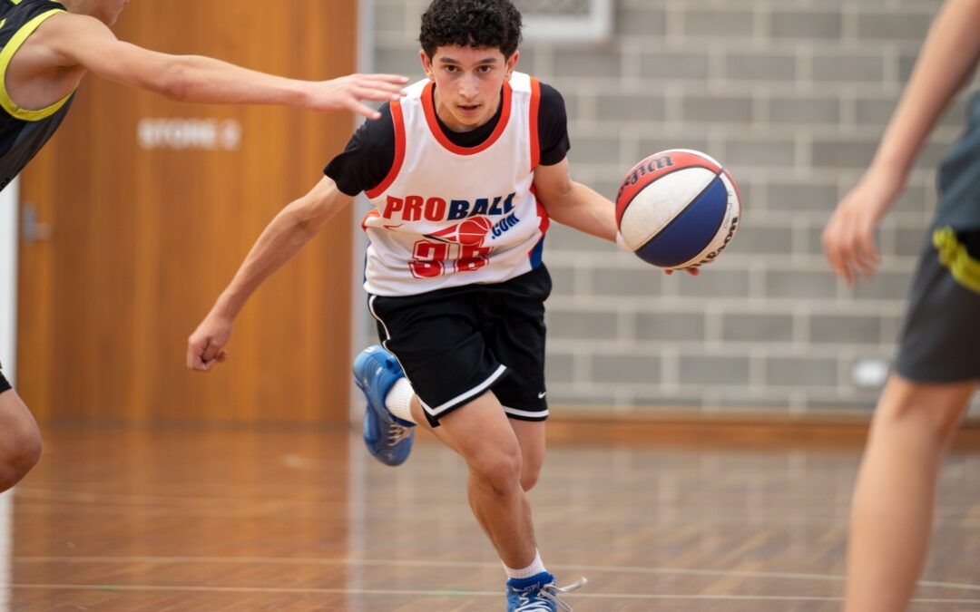 Youth basketball player mid-game preparing to shoot, showing focus, confidence and athletic performance development
