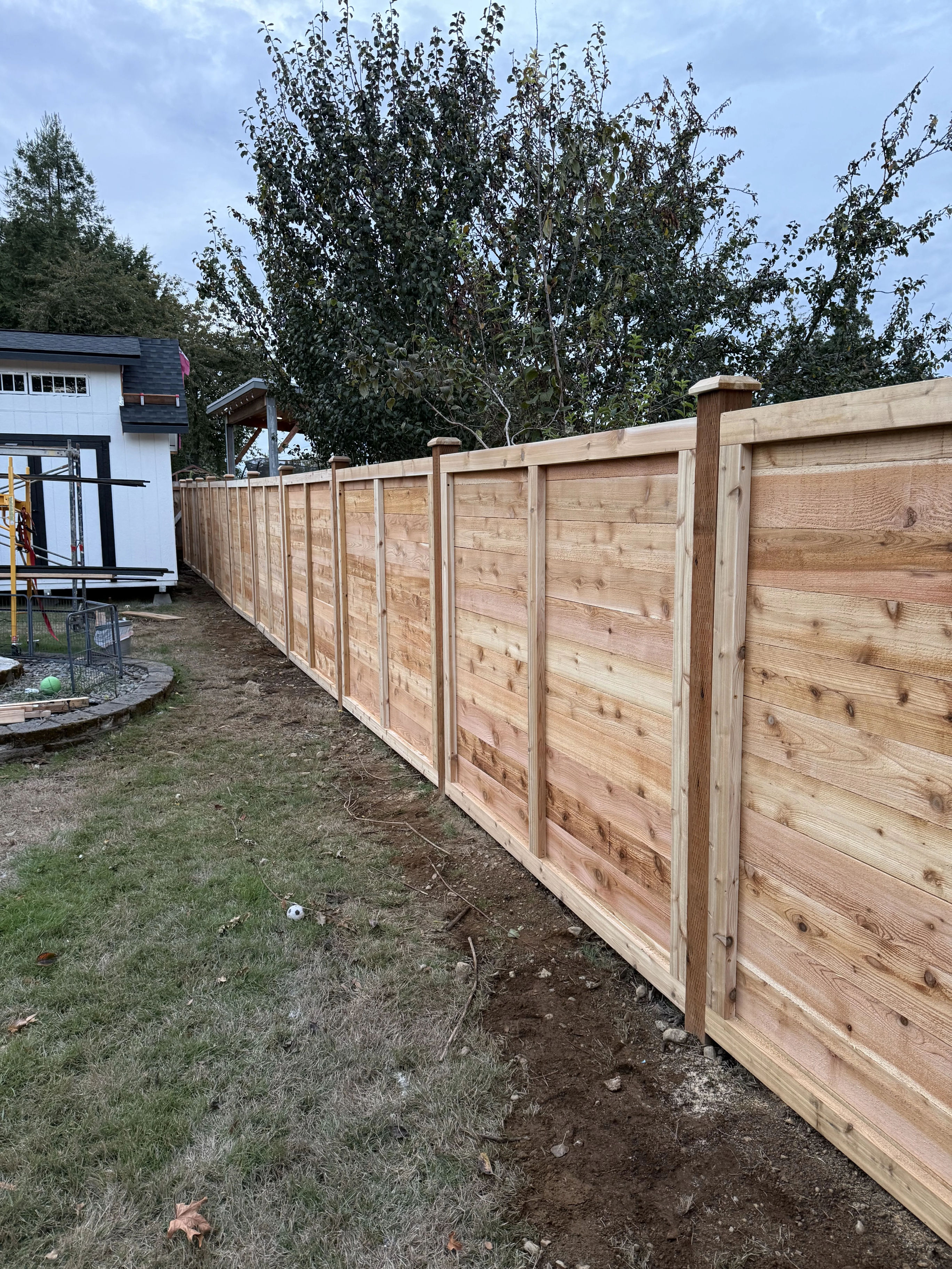 Long horizontal cedar fence in residential backyard