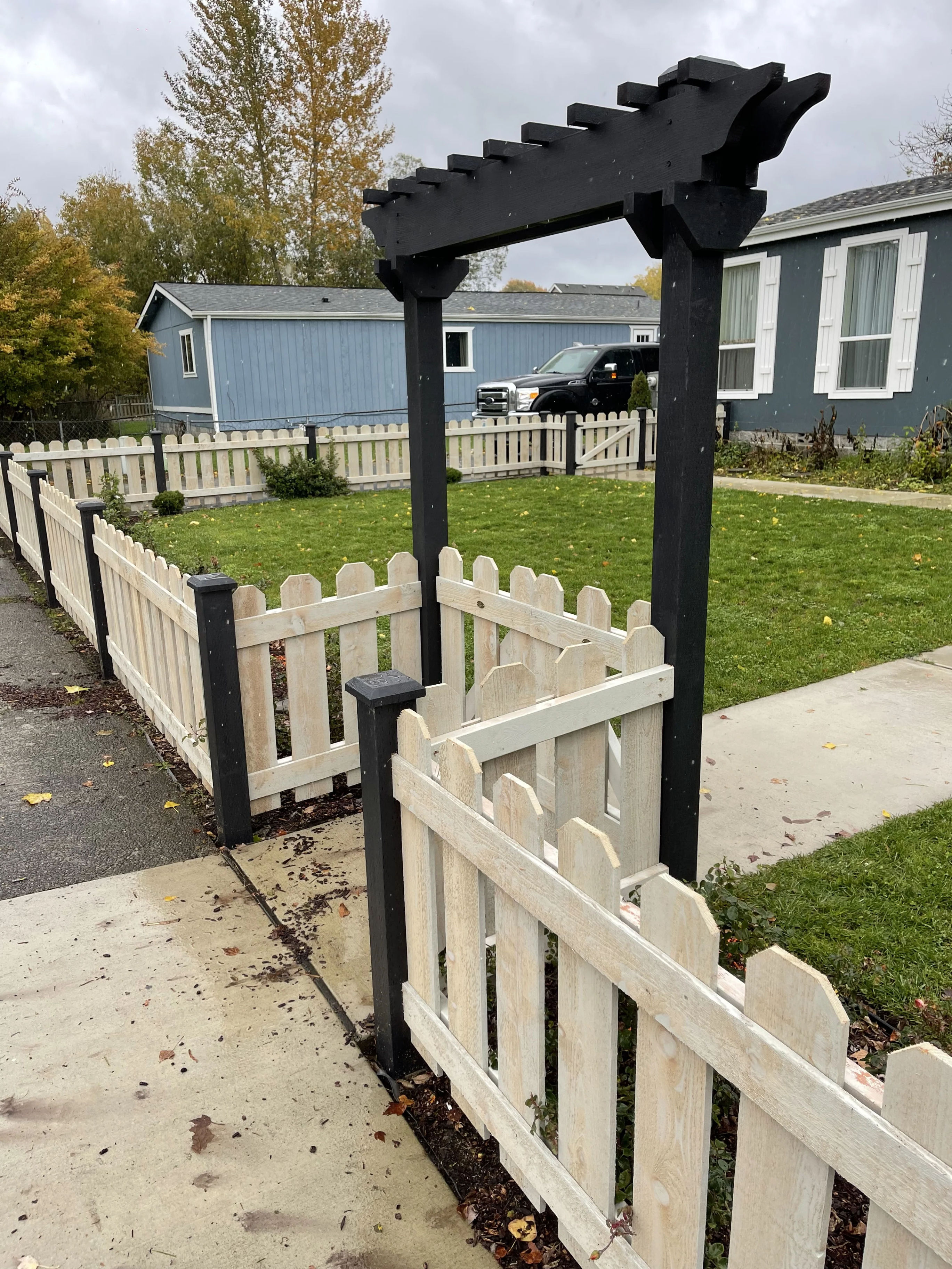 Picket fence gate detail with trellis overhead
