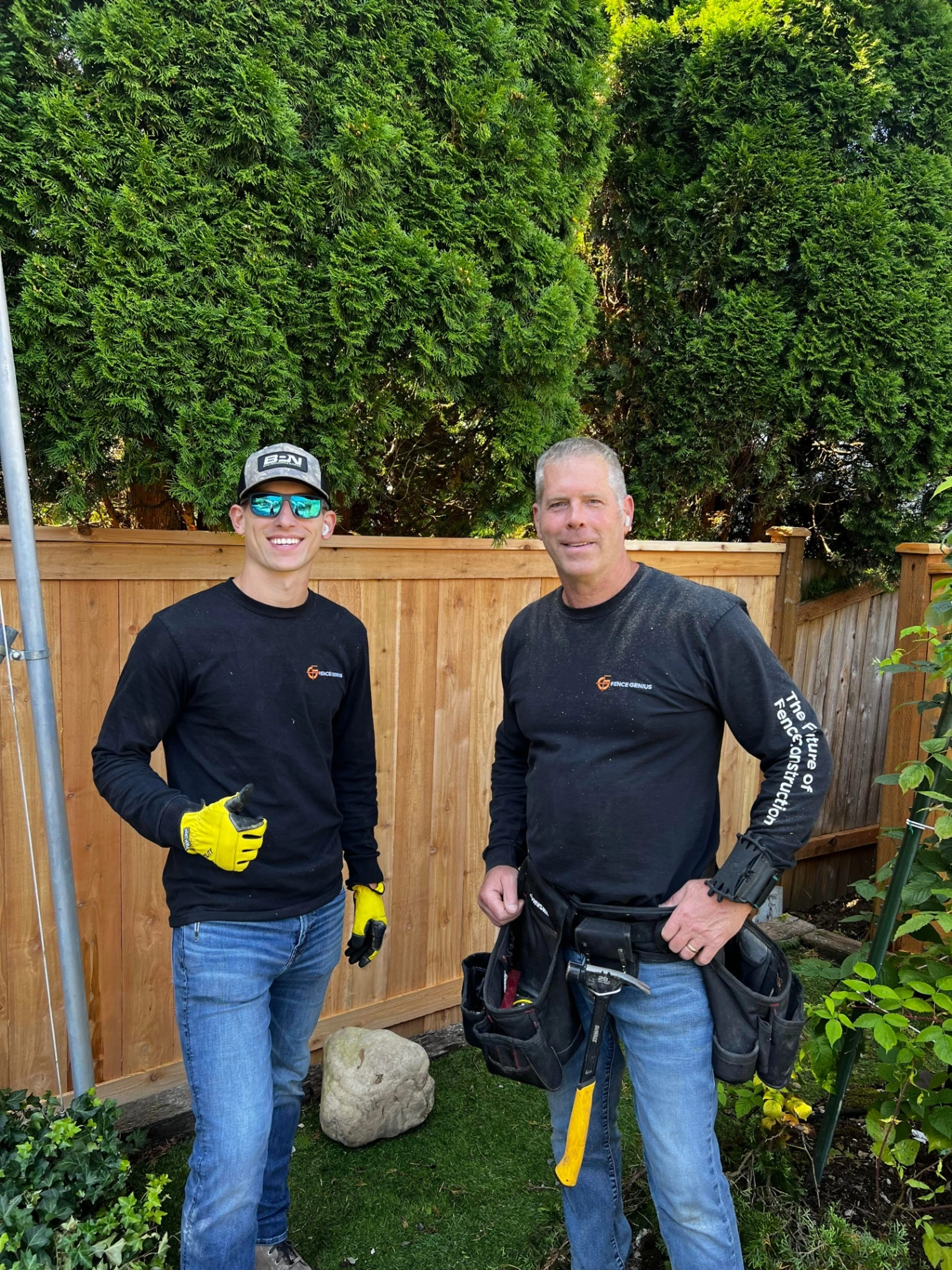 Father and son team at MyFence.com standing in front of a cedar fence in Seattle