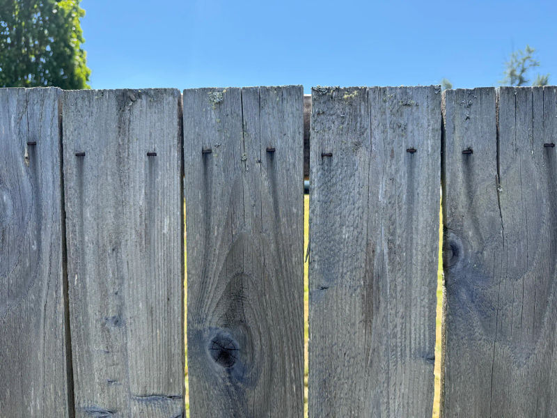 Close-up of galvanized fastener corrosion streaking down cedar