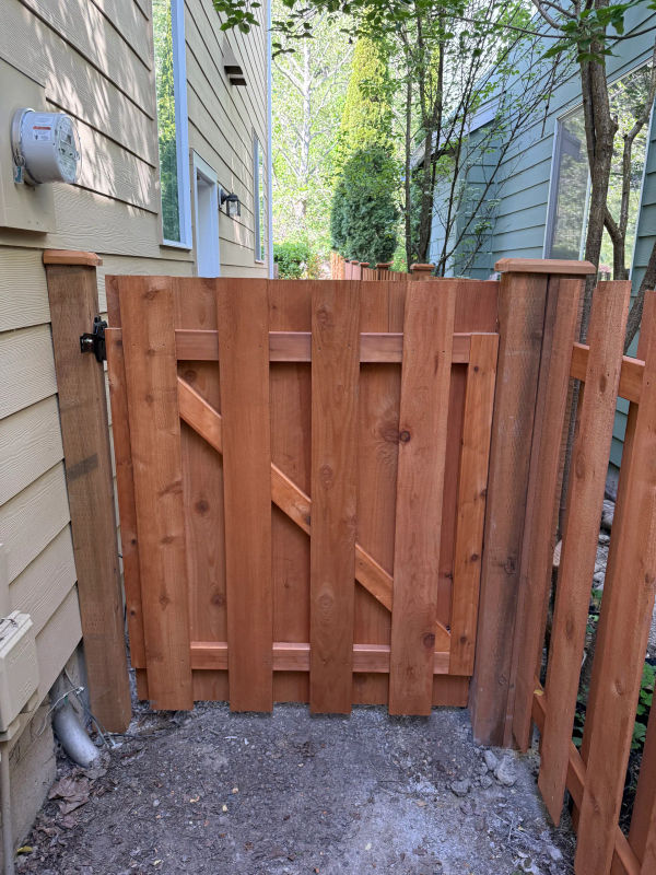 Cedar shadow box fence with custom gate in Maple Woods, Maple Valley, WA, showing the alternating board-on-board pattern.