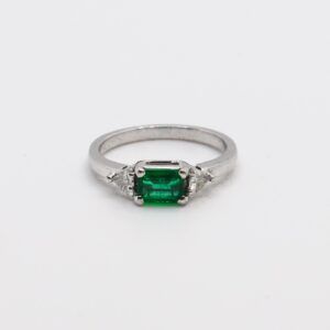 Anello in oro bianco 18 kt con diamanti triangolari e smeraldo naturale