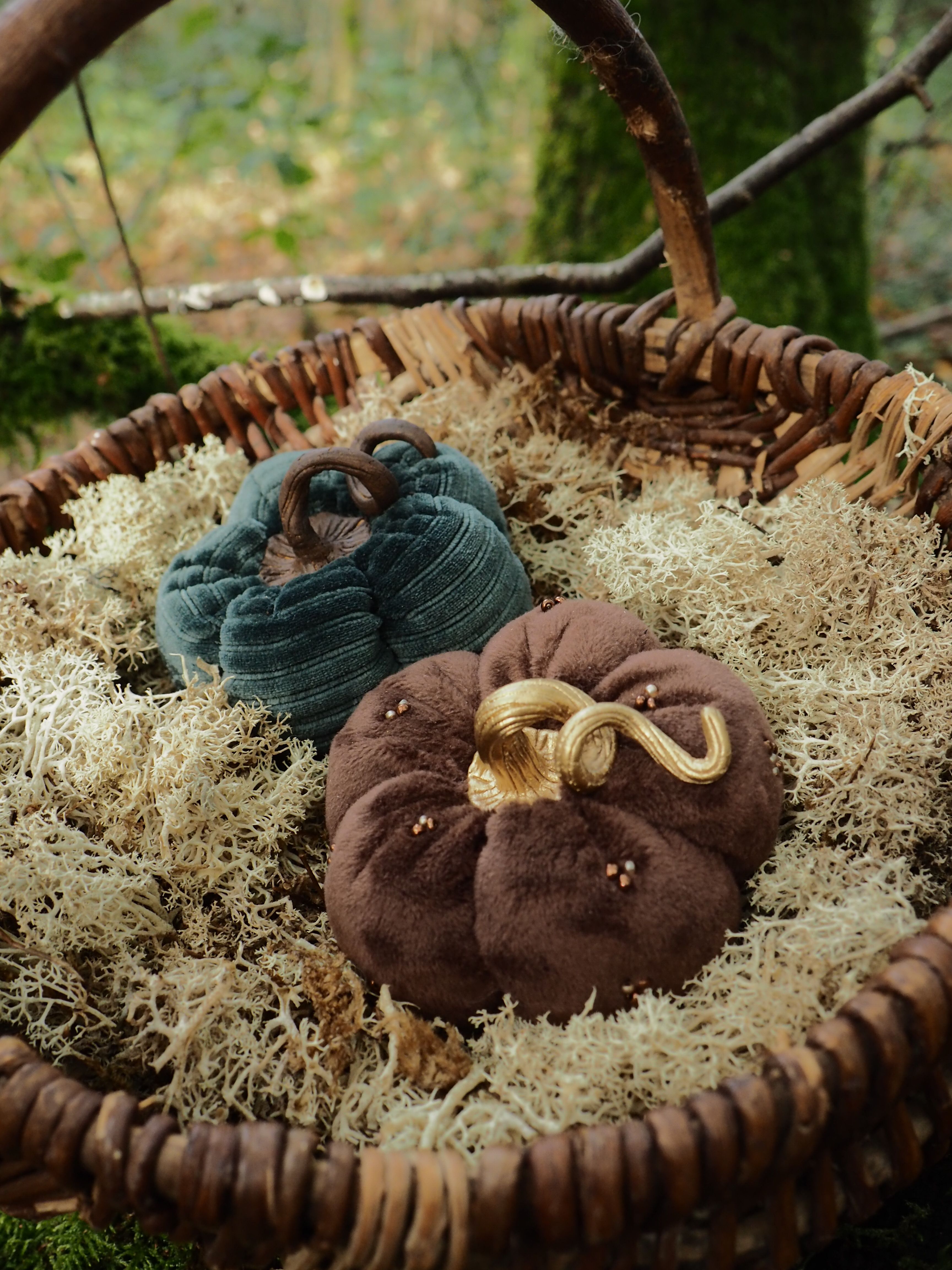 Cette image présente une scène de la Nativité artistiquement mise en scène dans un panier en osier tressé. La composition comprend : **Les personnages principaux :**
- Deux figurines représentant Marie et Joseph, vêtues de tissus aux tons terreux (brun et bleu-vert)
- Les figurines sont positionnées de manière à évoquer la scène traditionnelle de la naissance du Christ **L'environnement :**
- Un panier circulaire en osier naturel tressé qui sert de cadre à la scène
- Le fond du panier est garni de mousse ou de matériau naturel beige/doré qui imite la paille d'une étable
- L'ensemble repose sur ce qui semble être une surface naturelle avec de la végétation visible en arrière-plan **L'esthétique :**
- Le style est rustique et artisanal, privilégiant des matériaux naturels
- Les couleurs sont douces et terreuses, créant une atmosphère chaleureuse et authentique
- Cette représentation moderne de la Nativité allie tradition religieuse et créativité artisanale Cette mise en scène décorative capture l'essence de la Nativité dans un format compact et esthétiquement plaisant.