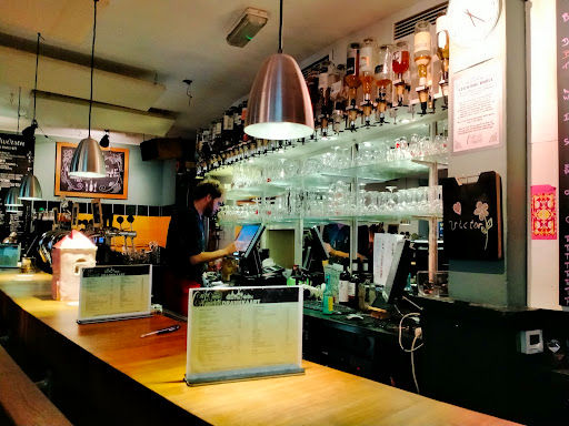 Cafe Averechts bar interior with stage area, pendant lighting, shelved backdrop, and performance space for live music.