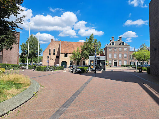 Observant bar's exterior courtyard with brick plaza, historic Dutch architecture, and open-air performance space.