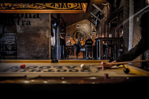 Boothill Saloon Amersfoort stage with live band, pool table, and bar seating in warm lighting.
