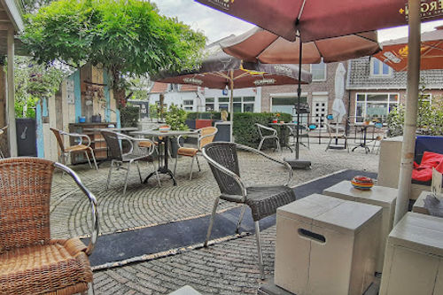 Food Place The Note outdoor patio with covered performance area, seating, and stage setup for live music events.