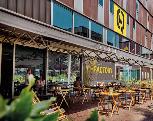 Q-Factory outdoor venue with yellow seating, stage area, and industrial architecture for live music performances.