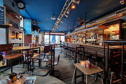 Café de Zaak bar interior with stage lighting rig, bar seating, and performance space for live music events.
