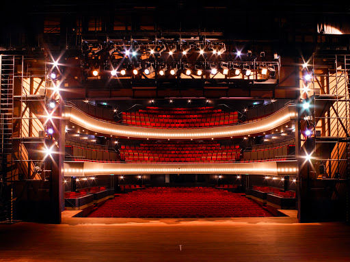 Flint live music venue with illuminated stage, red theater seating, professional lighting rigs, and sound equipment.