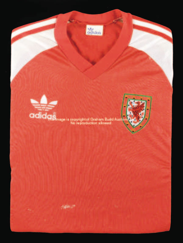 A red Wales No.3 international jersey, 1980s, short white sleeves, embroidered FAW badge  This jerse...