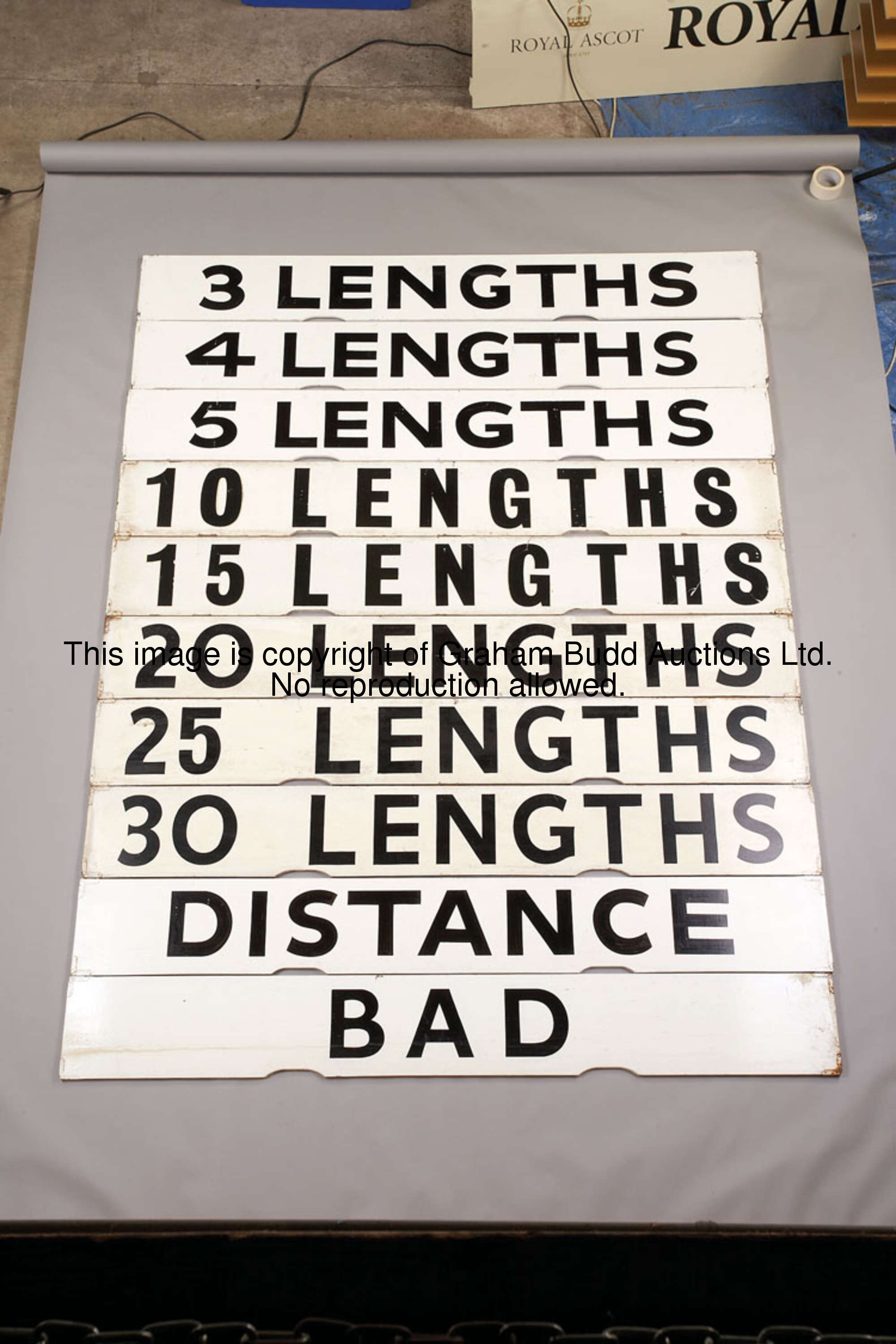 Bad, white painted wooden Spagnoletti winning distance board with black lettering, 25.5 by 100cm., 1...