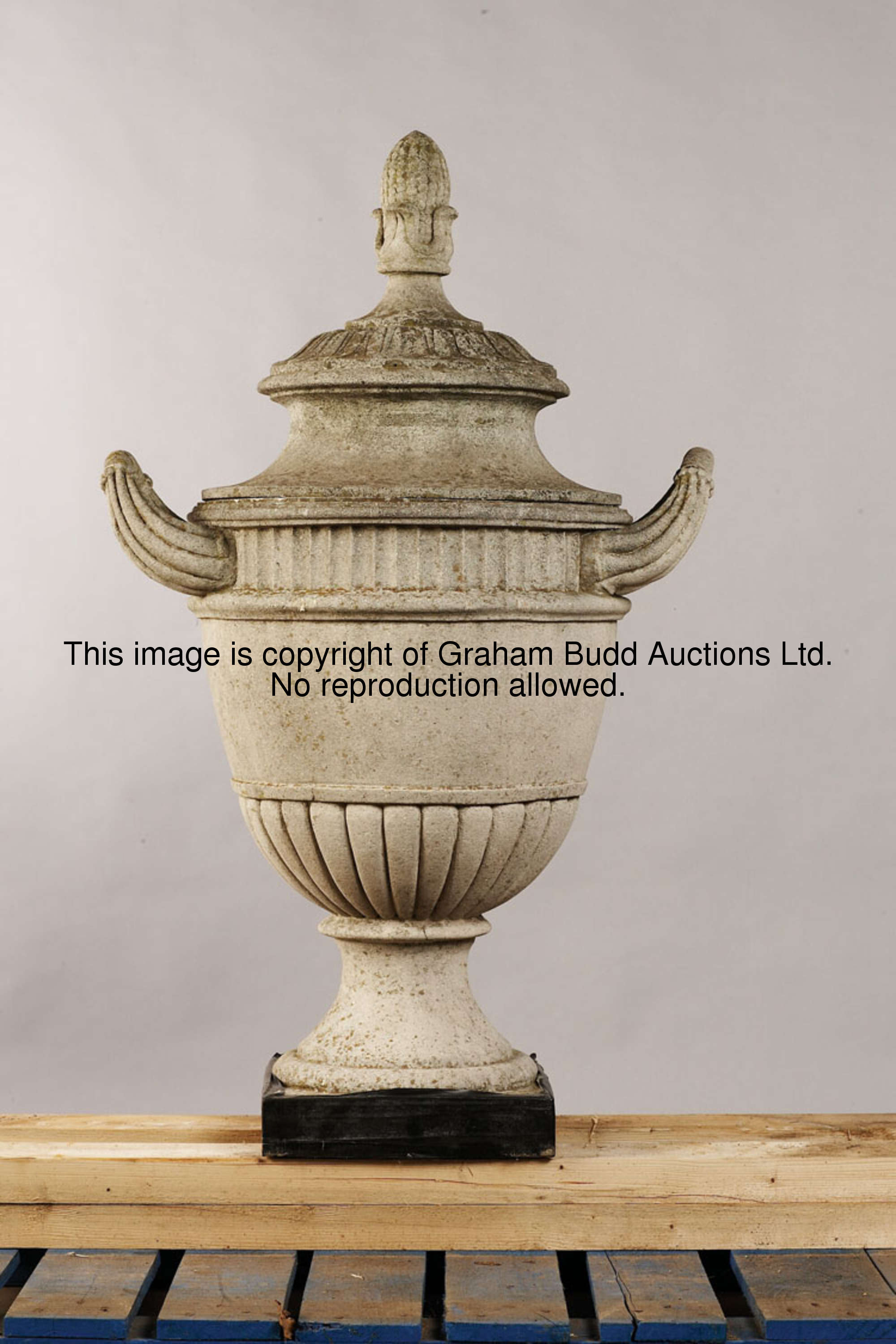 A pair of carved Portland stone urns and covers, 107cm., 42in. high