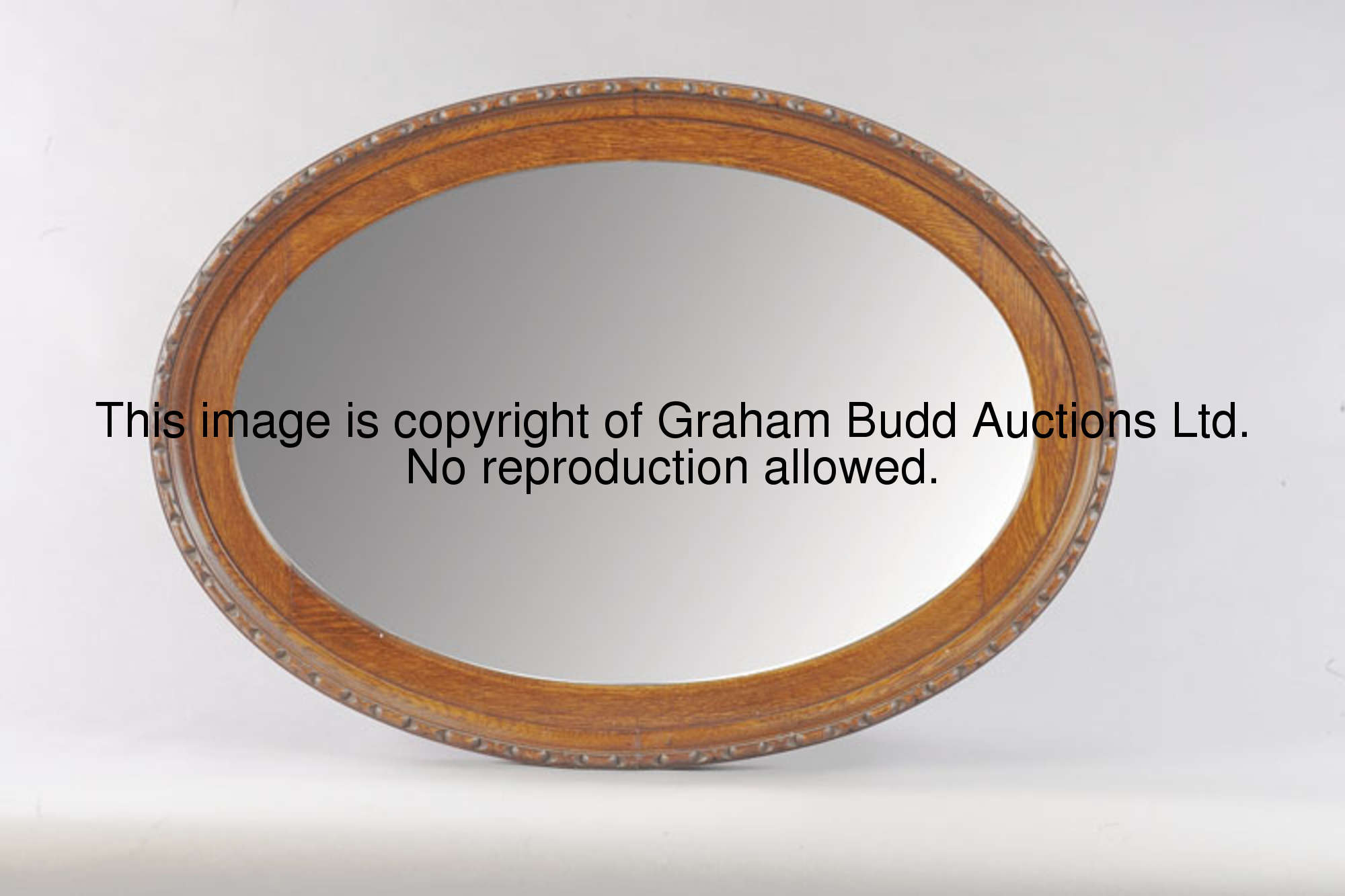 An oval mirror, the wooden frame with a moulded border, length 88cm., 34 1.2in., width 62cm., 24 1/2...