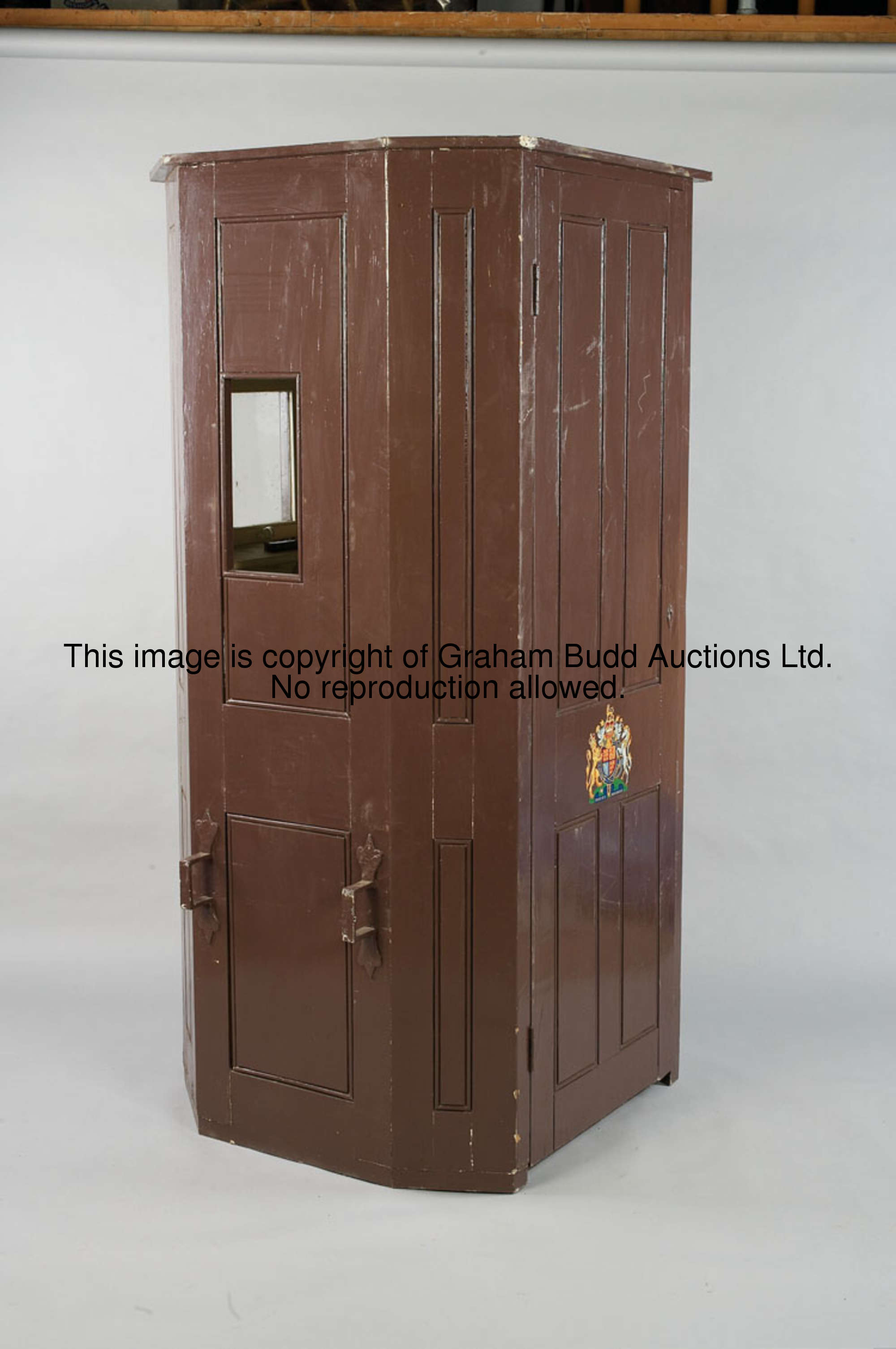 An Edwardian sedan-chair, bearing the royal coat of arms, brown painted wooden construction with gla...