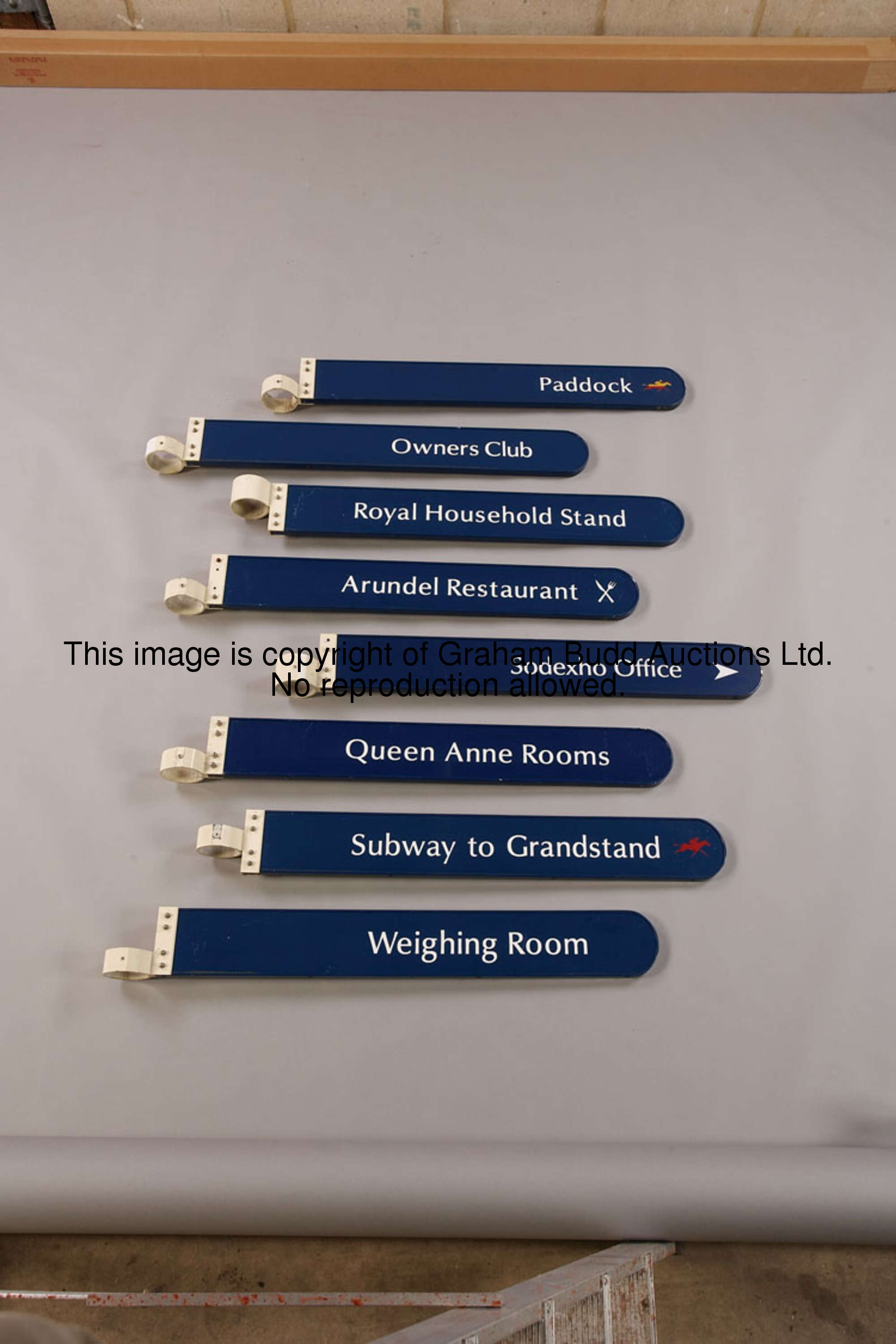 Paddock, metal finger-post sign, white lettering on blue with a gold & red stylised racehorse & jock...