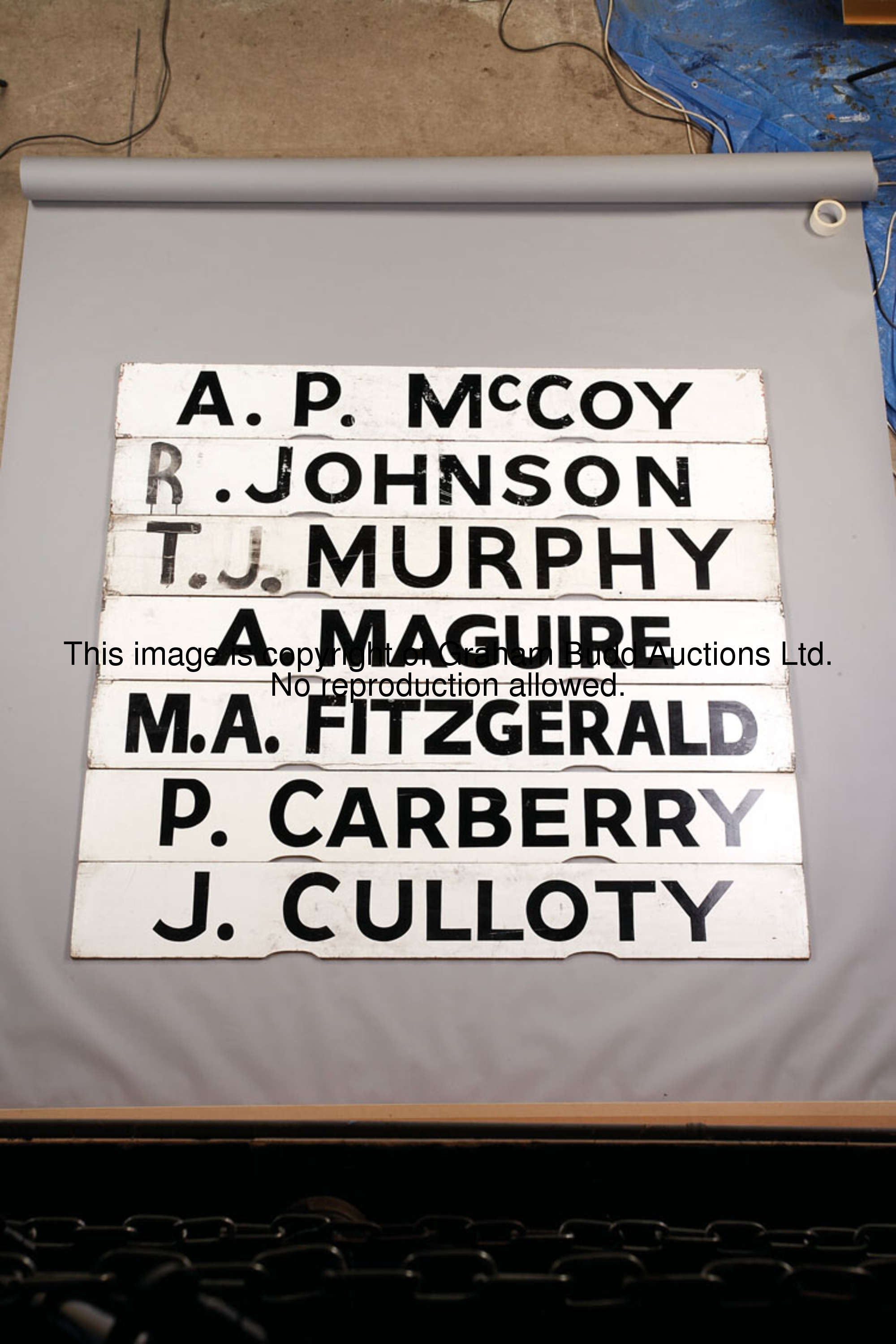 A. Maguire, white painted wooden Spagnoletti jockey board with black lettering, 25.5 by 100cm., 10 b...