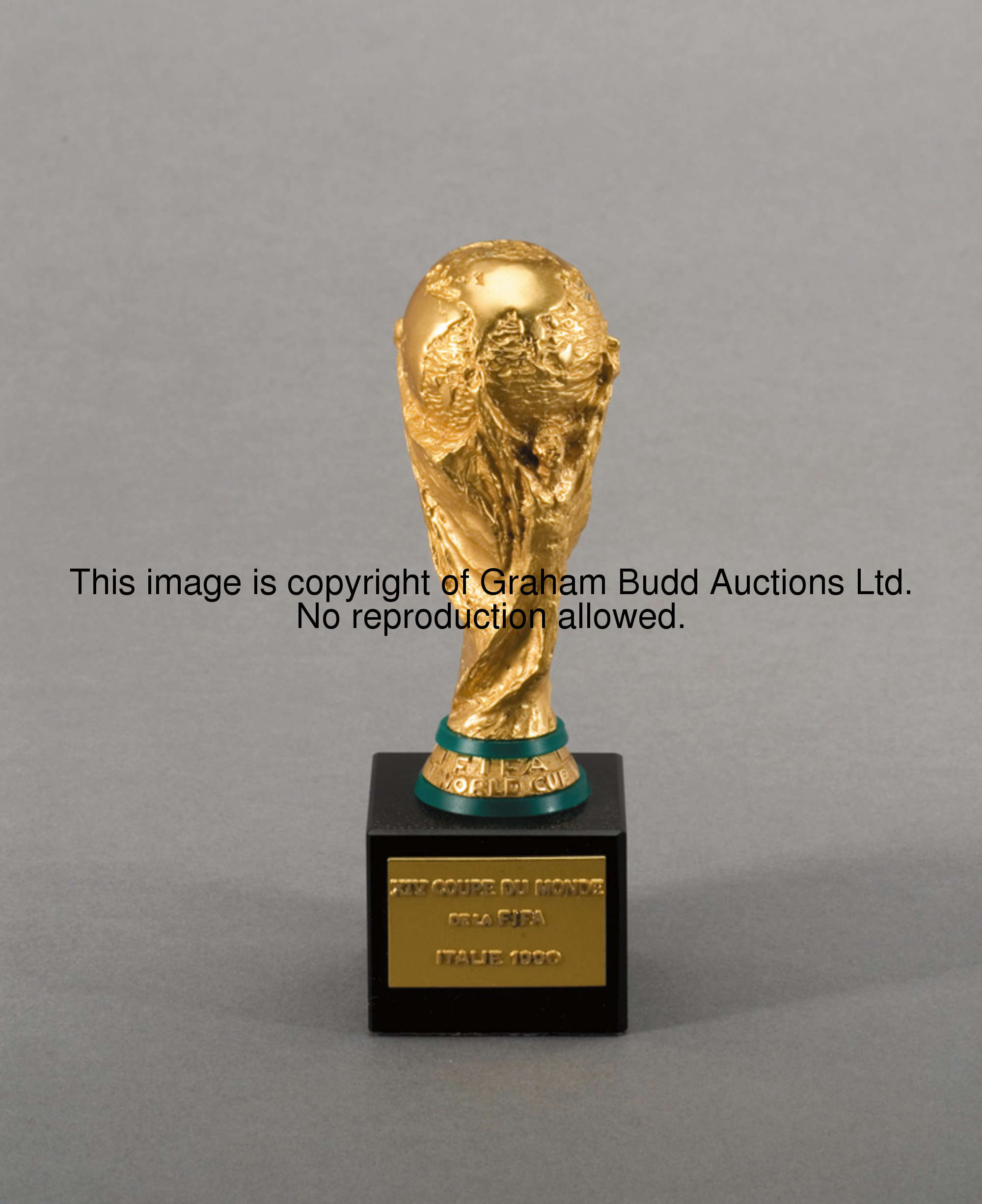 A gold plated miniature replica of the FIFA World Cup trophy, by Bertoni of Milan, set on a cubic bl...