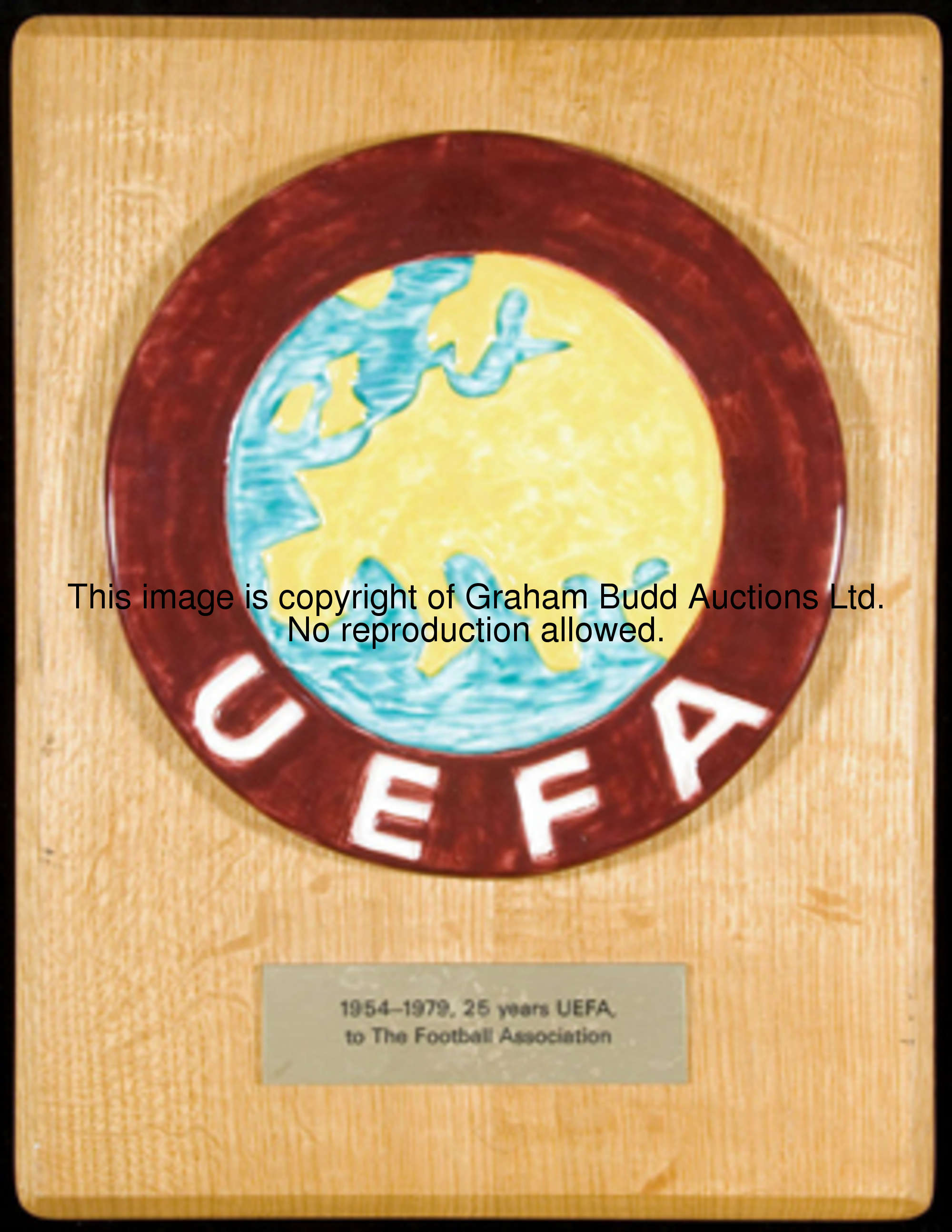 A UEFA plaque, in the form of a glazed ceramic roundel of the UEFA crest, mounted on a wooden backbo...