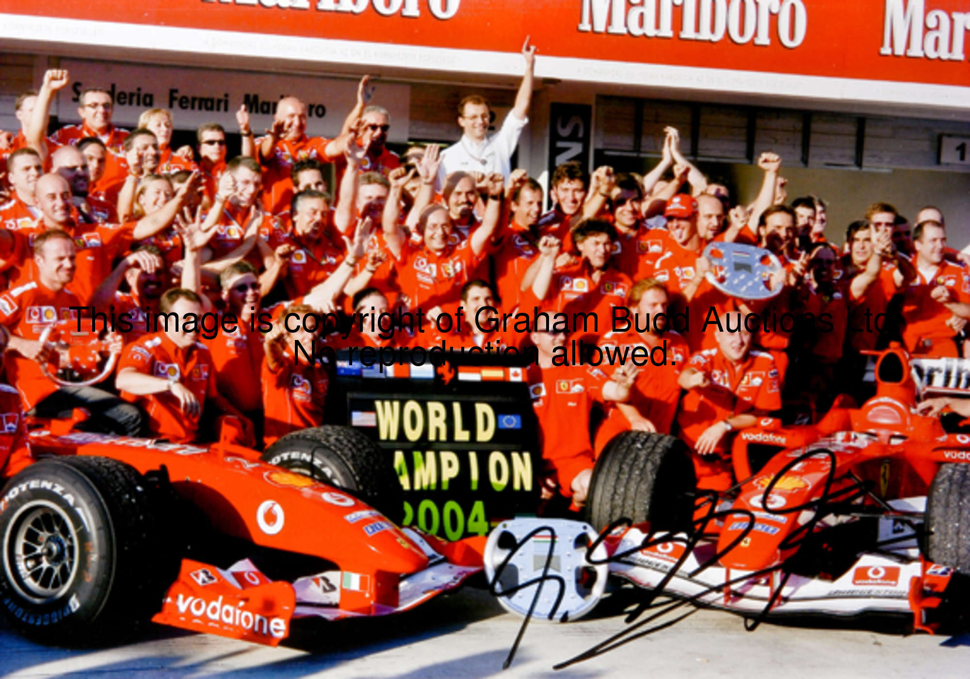 Michael Schumacher-signed Scuderia Ferrari press photos, two large colour prints from the 2004 seaso...
