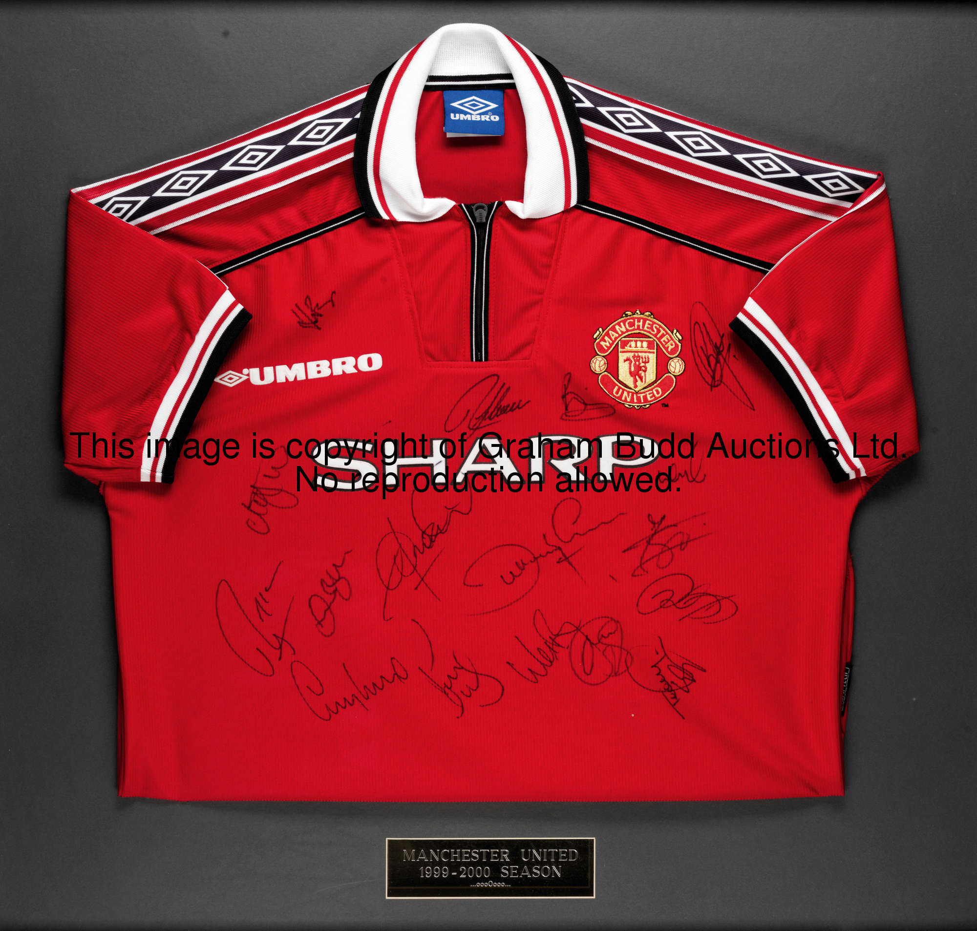 A red replica Manchester United jersey signed by the 1999 Treble Winners, 17 signatures in black mar...